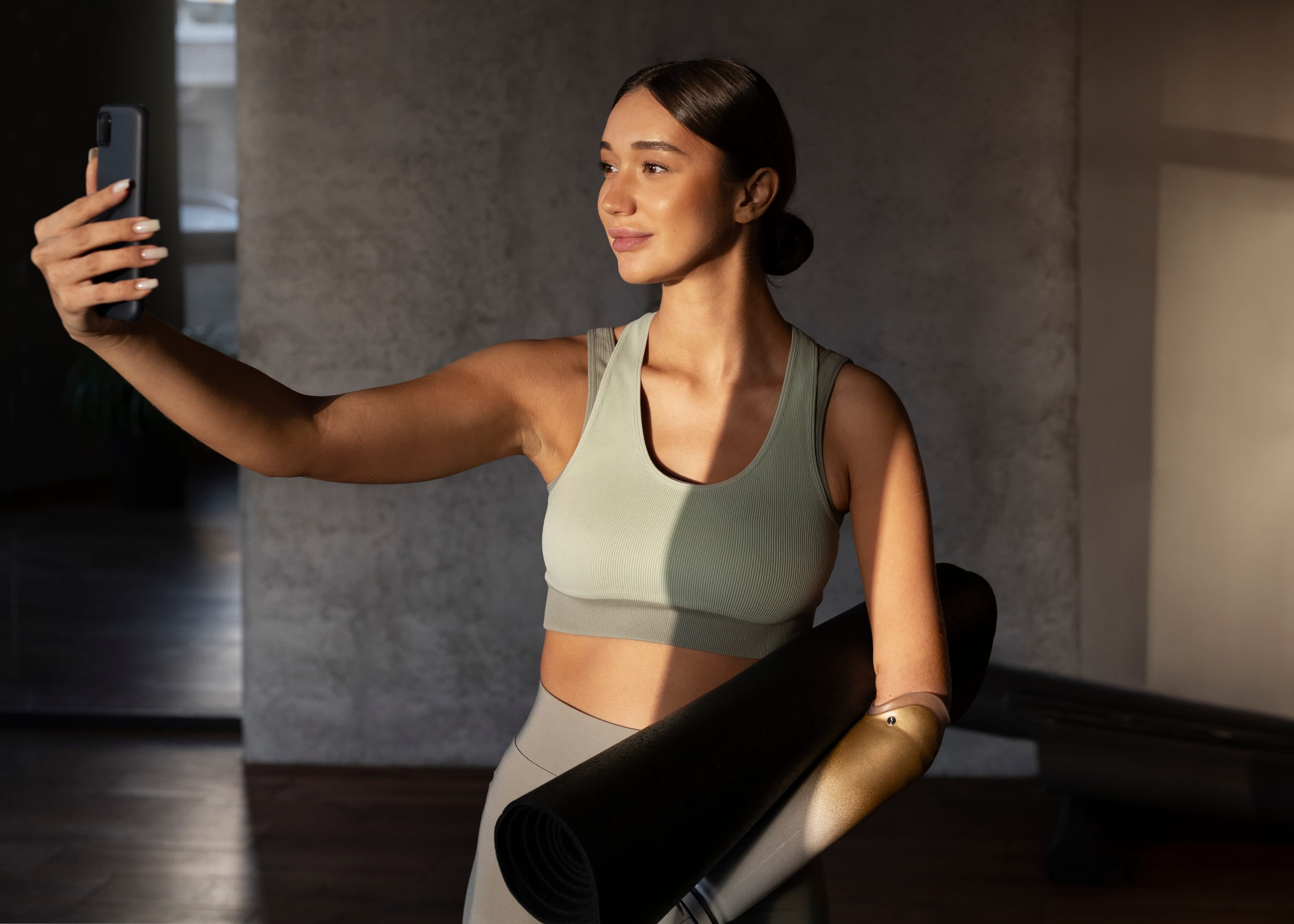 Mulher fazendo uma selfie segurando um tapete de yoga Mulher fazendo uma selfie segurando um tapete de yoga