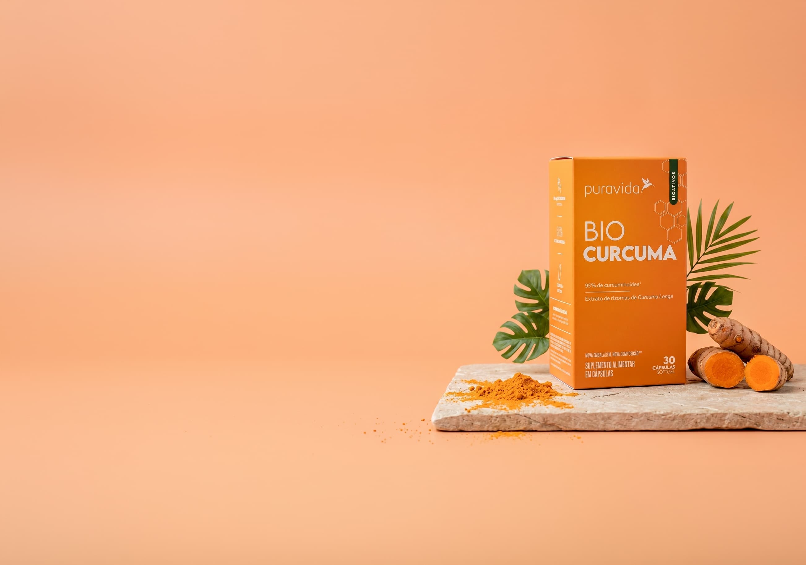 Bio Curcuma - ingredientes Cartucho Bio Curcuma sobre pedra com raízes de cúrcuma