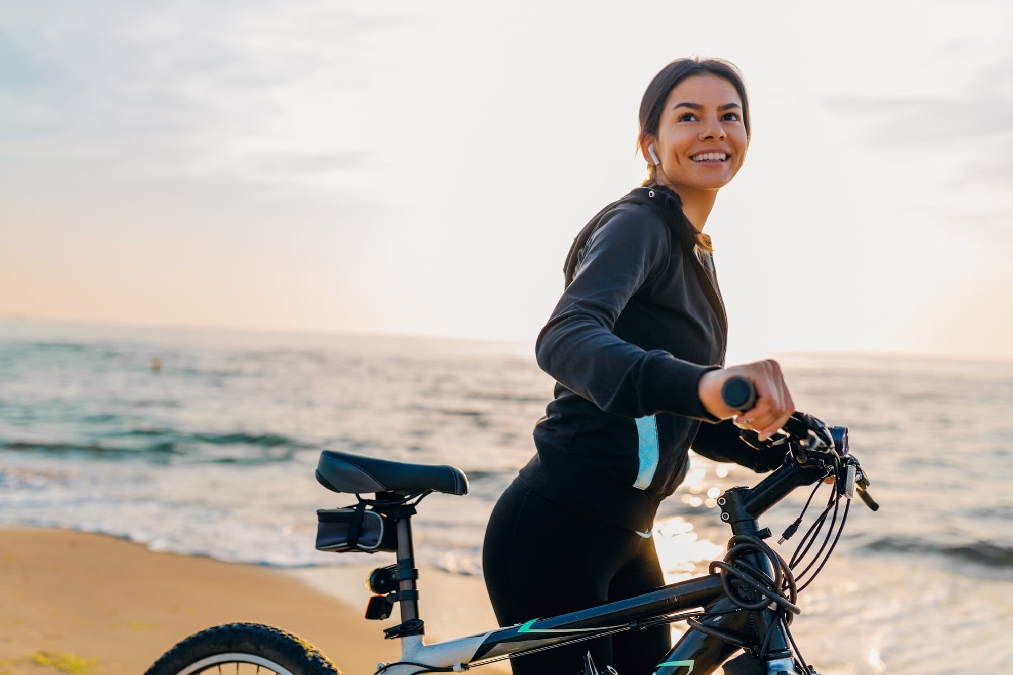 Mulher em bicicleta à beira-mar Mulher em bicicleta à beira-mar