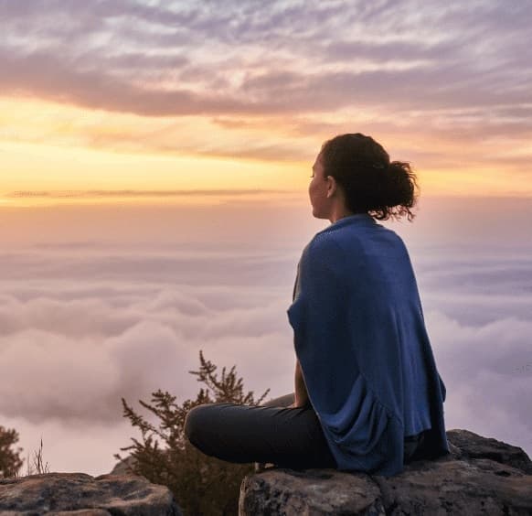 Mulher meditando ao entardecer