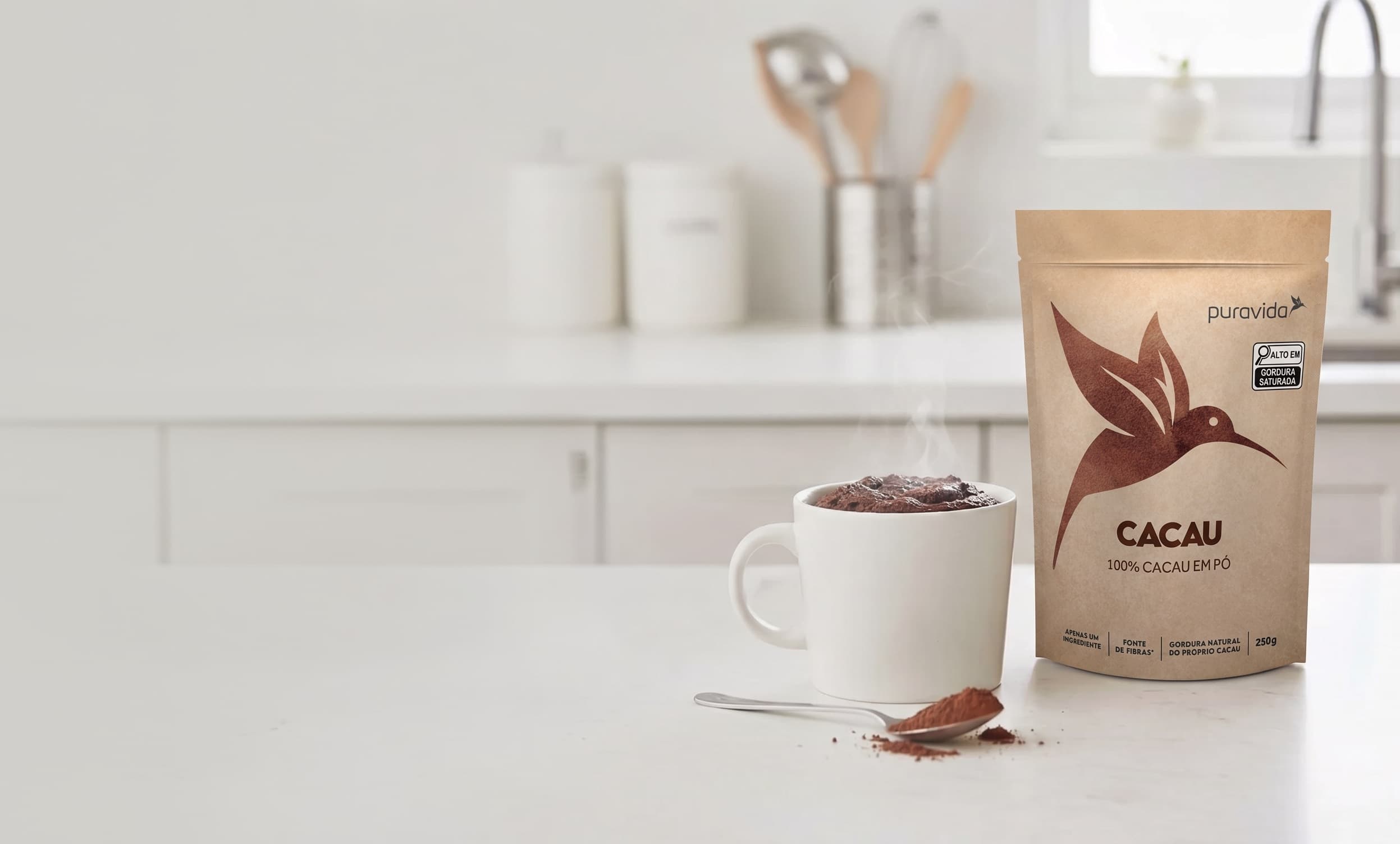 Pouch de Cacau em Pó Puravida em bancada de cozinha com caneca de chocolate quente Pouch de Cacau em Pó Puravida em bancada de cozinha com caneca de chocolate quente