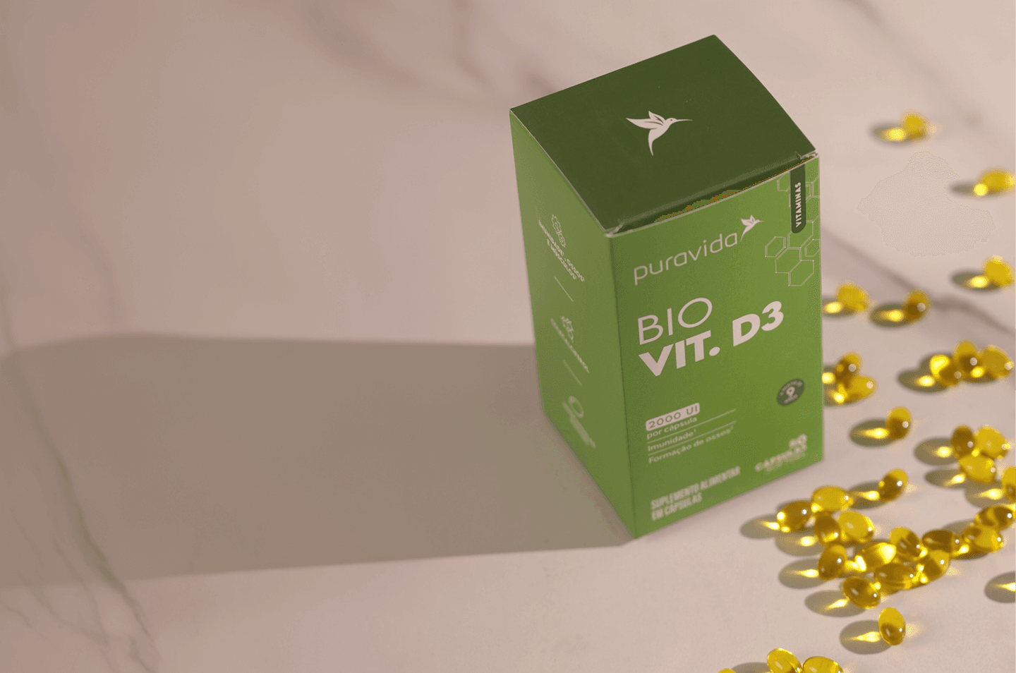 Bio Vit. D3 — ingredientes Caixa e pote de Bio Vit. D3 com folhagens sobre fundo verde