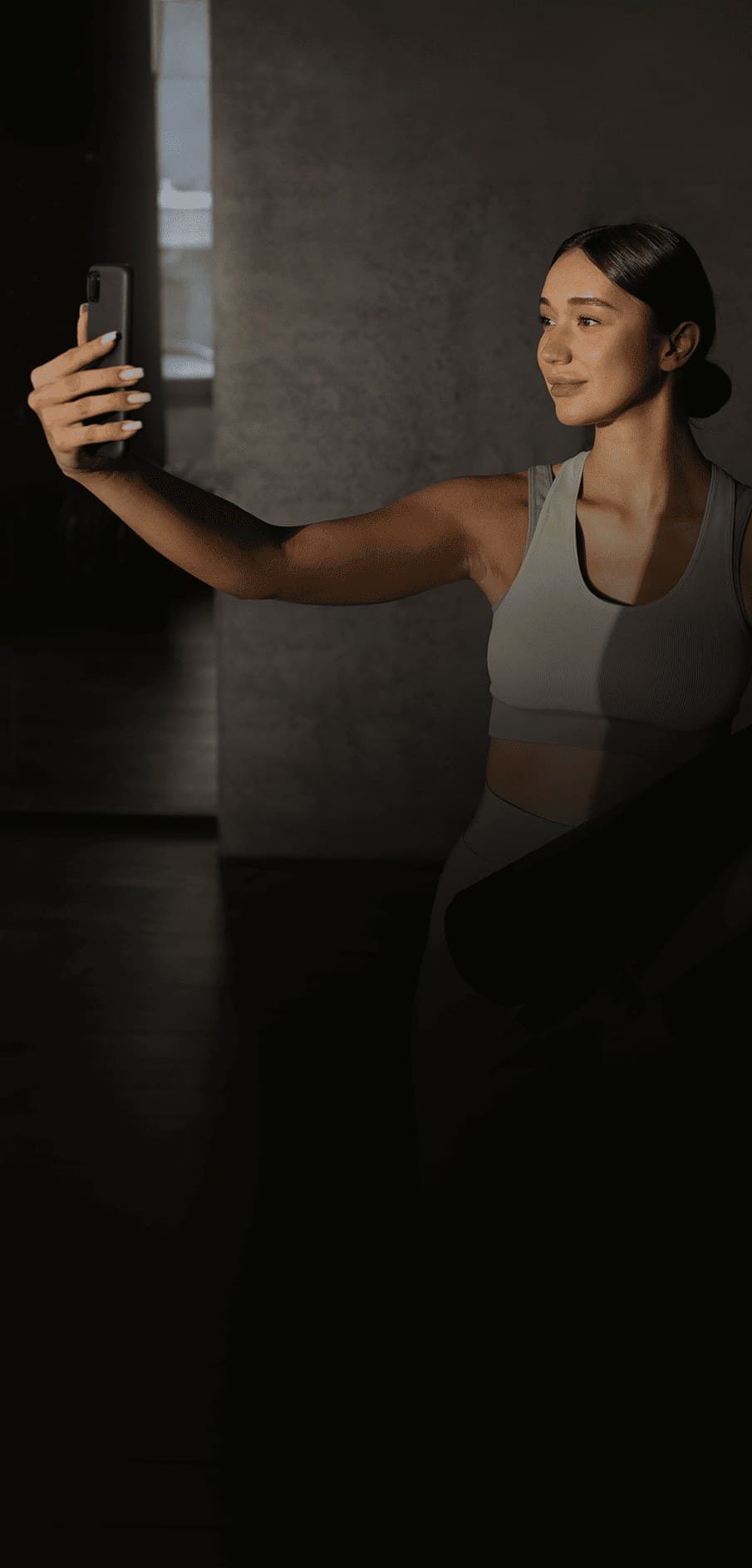 Mulher fazendo uma selfie segurando um tapete de yoga Mulher fazendo uma selfie segurando um tapete de yoga