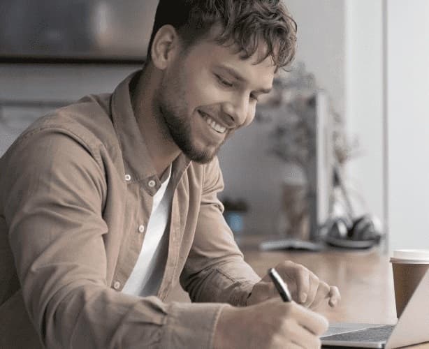 Homem escrevendo em ambiente de trabalho