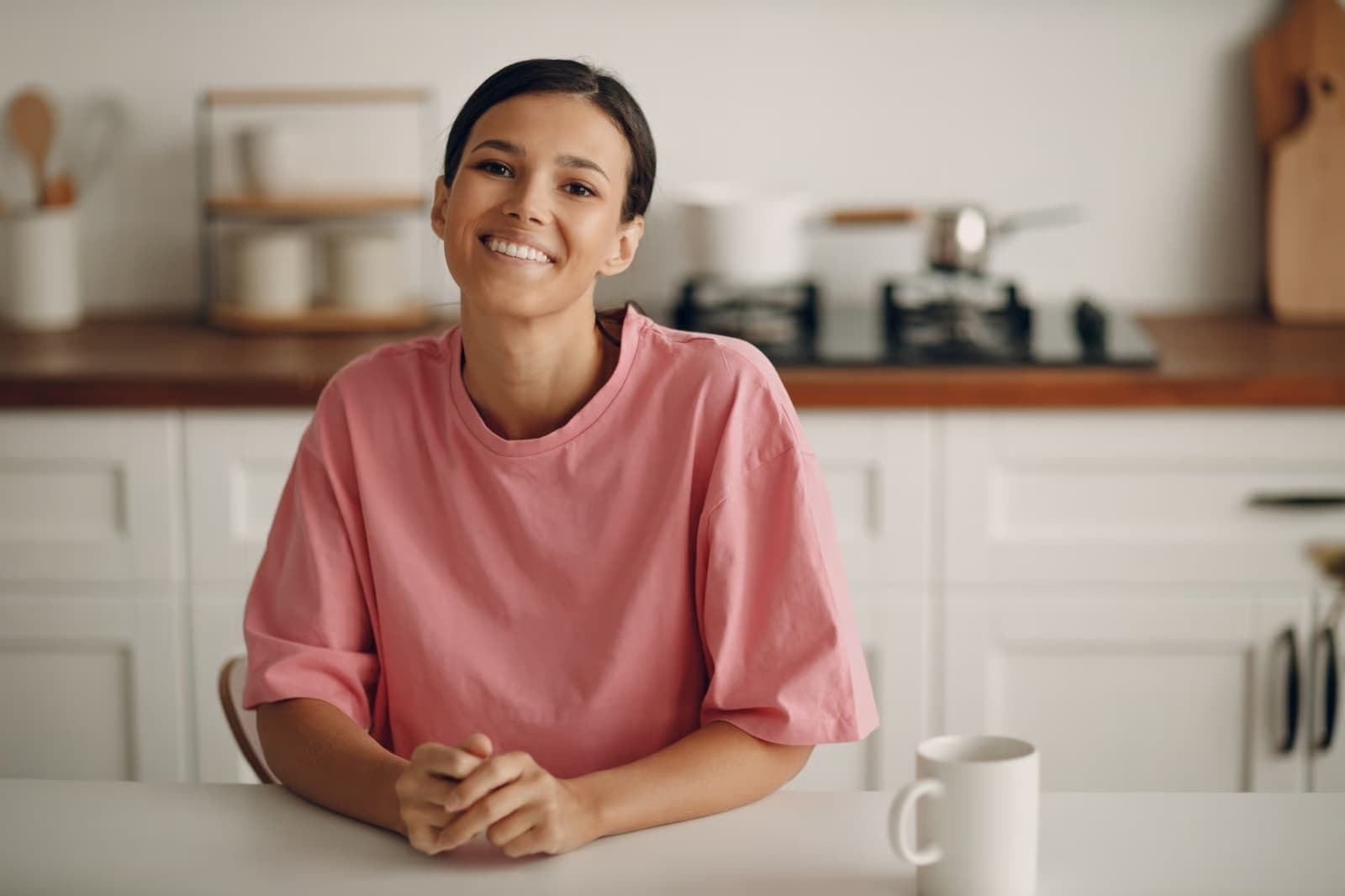 Rotina leve com Alpha Harmony Mulher sorrindo apoiada na bancada da cozinha