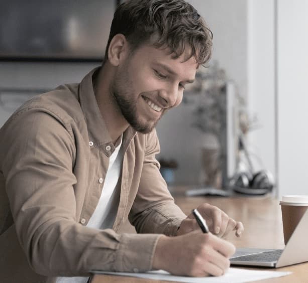 Homem escrevendo em ambiente de trabalho
