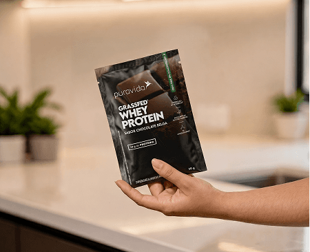 Mão segurando o pouch Whey Grassfed Mão segurando o pouch Whey Grassfed