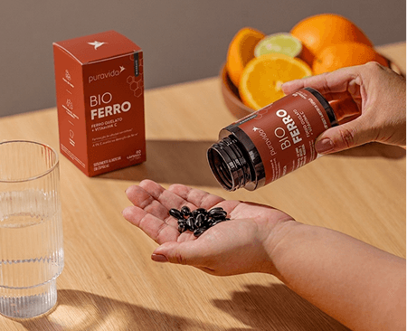 Frasco de Bio Ferro com cápsulas e laranjas Frasco de Bio Ferro com cápsulas e laranjas